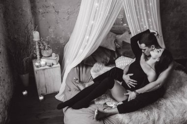 Genç ve seksi bir çift yatakta poz veriyor..