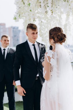 Düğün töreninde birbirlerine bakan genç ve güzel bir çift.