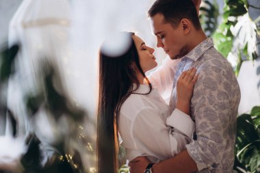 Mutlu, genç bir çift sıcak bir odada sarılıyor.  