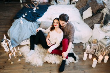 Güzel, mutlu, birbirine aşık genç bir çift sıcak bir odada kucaklaşıyorlar..                   