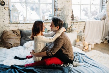 Güzel, mutlu, birbirine aşık genç bir çift sıcak bir odada kucaklaşıyorlar..                   