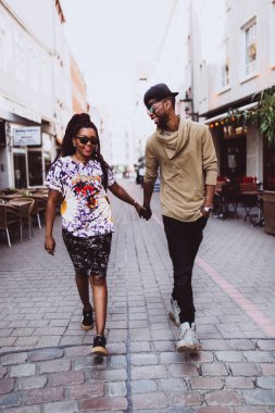 Genç, güzel siyah çift şehirde güneş gözlükleriyle poz veriyor.