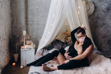 Genç ve seksi bir çift yatakta poz veriyor..