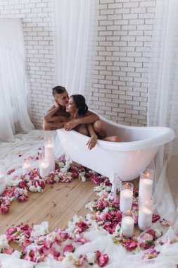 Güzel, şehvetli, genç bir çift banyoda sarılıyor ve dinleniyor.            