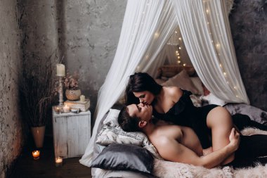 Genç ve seksi bir çift yatakta poz veriyor..