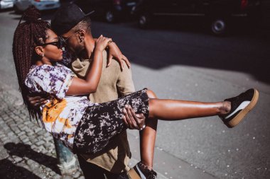 Genç, güzel siyah çift şehirde güneş gözlükleriyle poz veriyor.