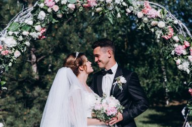 Yeni evlilerin düğün günü. Gelin ve damat açık hava düğün töreninde..