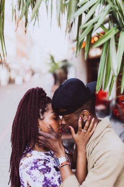 Afrikalı çift sokakta öpüşüyor ve sarılıyor.