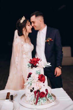 Gelin ve damat masada güzel bir düğün pastası ile