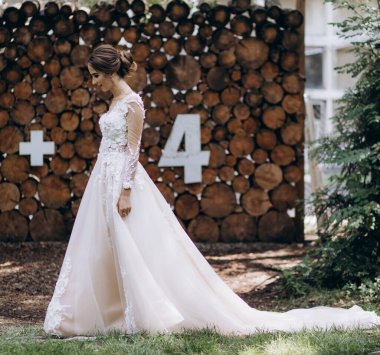 Parktaki gelinlik içinde uzun saçlı güzel bir gelin.