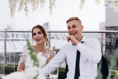 Gelin ve damat düğün masasında birlikte oturuyorlar.                    