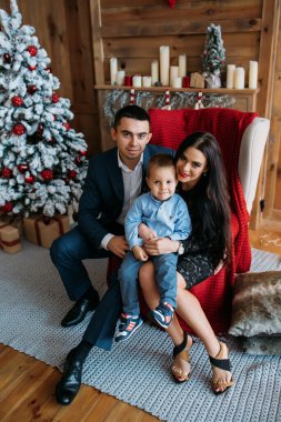 Stüdyoda oğluyla mutlu bir aile Noel ağacı süslemesi yapıyor.