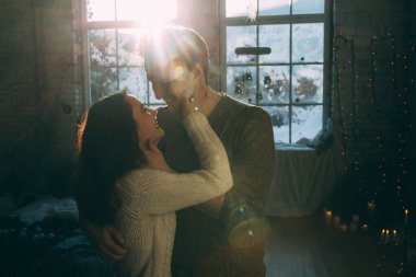 Güzel, mutlu, birbirine aşık genç bir çift sıcak bir odada kucaklaşıyorlar..                   