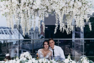 Gelin ve damat düğün masasında birlikte oturuyorlar.                    