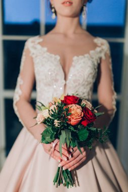 Güzel gelinin yakın plan görüntüsü ellerinde düğün buketiyle.     