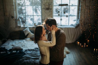 Güzel, mutlu, birbirine aşık genç bir çift sıcak bir odada kucaklaşıyorlar..                   