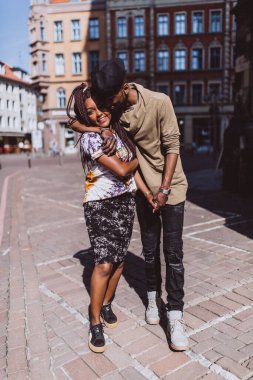 Mutlu, genç, Afro-Amerikan çift şehir caddesinde birlikte yürüyor.