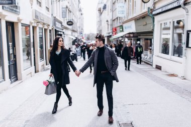 Genç aşık bir çift şehir sokaklarında yürüyor. 