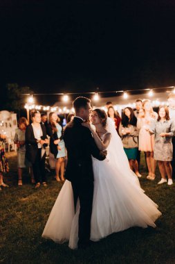 Mutlu genç bir çift gece dışarıda dans ediyor.