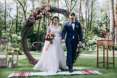 Ormandaki güzel bir düğün çifti Ulusal Ukrayna havlusunun üzerinde duruyor.