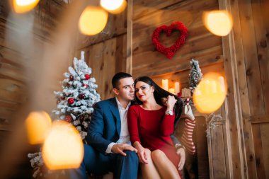 Şöminenin yanında birbirine aşık mutlu çift poz veriyor. 