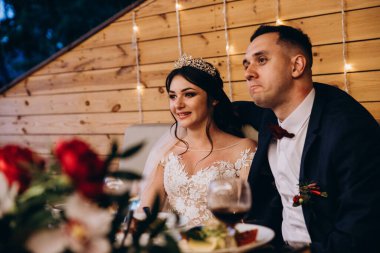 Genç, güzel gelin ve damat restoranda masada oturuyor.