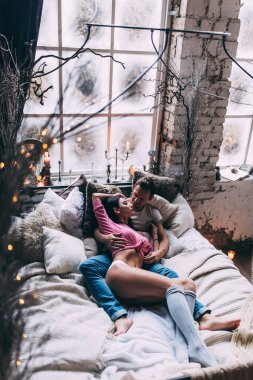 Genç bir çift güzel bir iç döşemesi olan bir yatakta