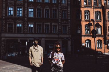 Genç, güzel siyah çift şehirde güneş gözlükleriyle poz veriyor.