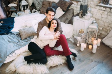 Güzel, mutlu, birbirine aşık genç bir çift sıcak bir odada kucaklaşıyorlar..                   