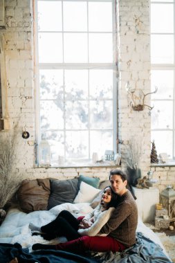 Genç çift oturup fotoğraf çekiminde poz veriyor. 