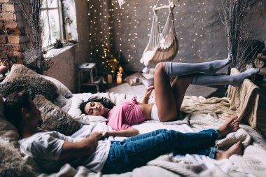 Yatakta genç ve güzel bir çiftin stüdyo fotoğrafı.