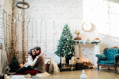 Genç çift oturup fotoğraf çekiminde poz veriyor. 