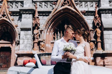 Kilisenin yanında poz veren mutlu genç bir çift.