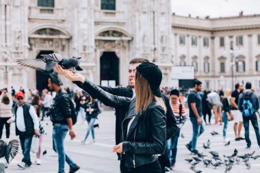 Mutlu çift İtalya 'da Duomo di Milano' nun önünde güvercinlerle poz veriyor.