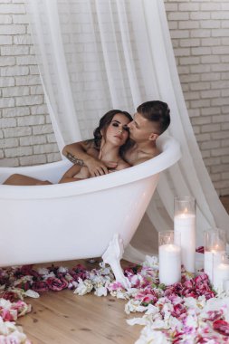 Güzel, şehvetli, genç bir çift banyoda sarılıyor ve dinleniyor.            