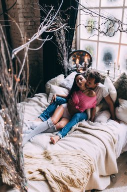 Yatakta genç ve güzel bir çiftin stüdyo fotoğrafı.