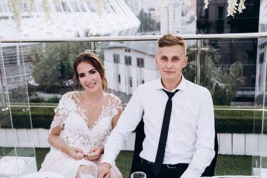 Gelin ve damat düğün masasında birlikte oturuyorlar.                    