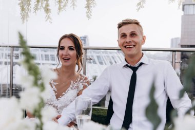 Gelin ve damat düğün masasında birlikte oturuyorlar.                    