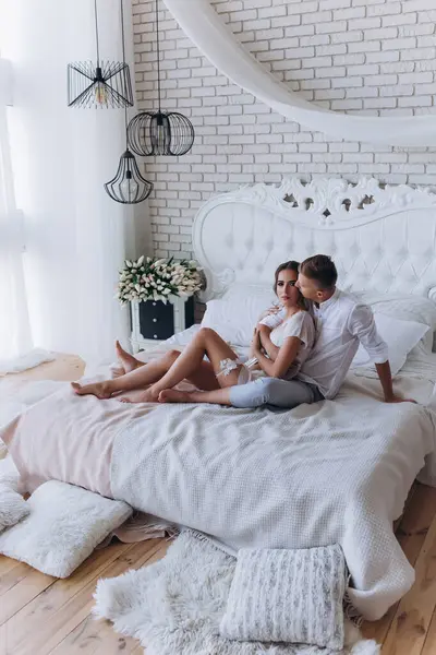 Güzel, genç ve mutlu bir çift yatak odasında birlikte oturuyor.              