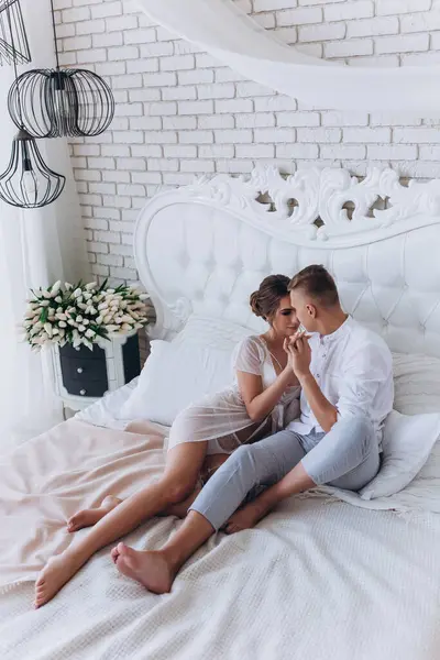 Güzel, genç ve mutlu bir çift yatak odasında birlikte oturuyor.              