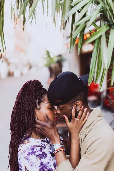 Afrikalı çift sokakta öpüşüyor ve sarılıyor.