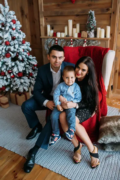 Stüdyoda oğluyla mutlu bir aile Noel ağacı süslemesi yapıyor.