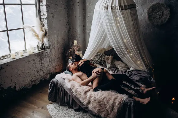 Genç ve seksi bir çift yatakta poz veriyor..