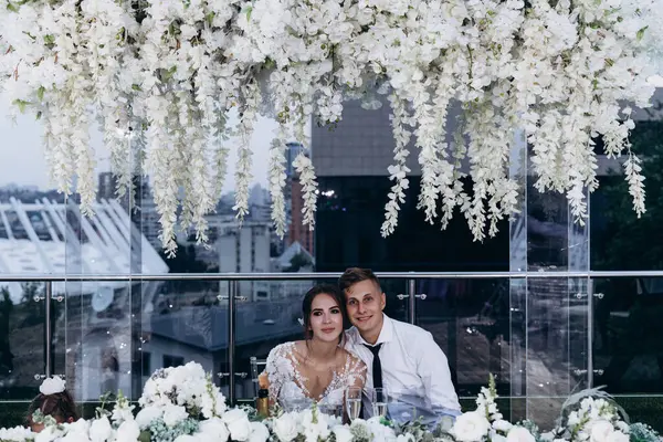 Gelin ve damat düğün masasında birlikte oturuyorlar.                    