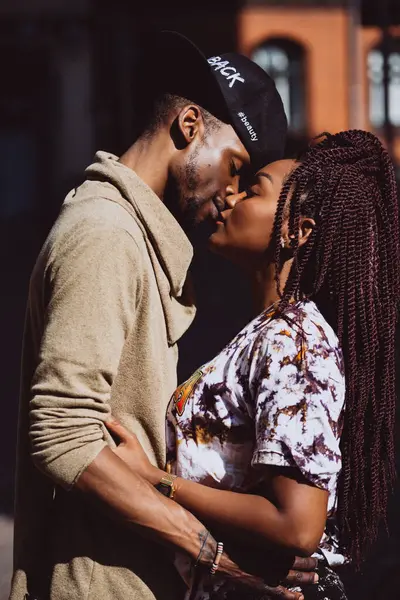 Afrikalı çift sokakta öpüşüyor ve sarılıyor.