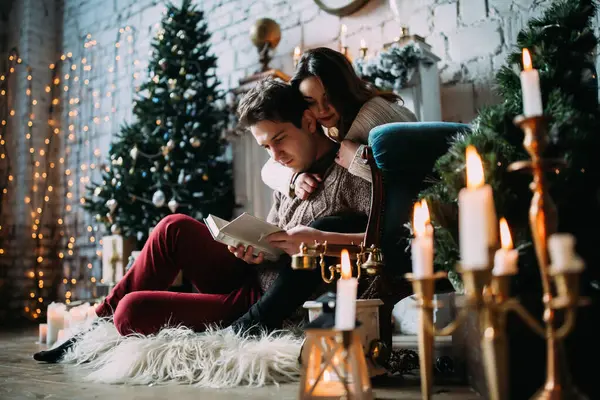 Güzel genç bir çift yeni yılı kutluyor ve akşamları evde kitap okuyor..       