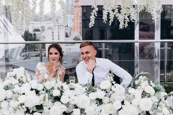 Gelin ve damat düğün masasında birlikte oturuyorlar.                    