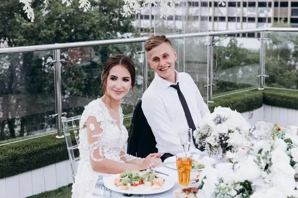 Gelin ve damat düğün masasında birlikte oturuyorlar.                    