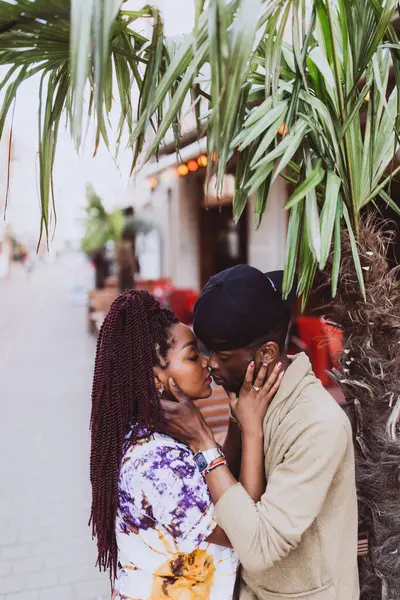 Afrikalı çift sokakta öpüşüyor ve sarılıyor.
