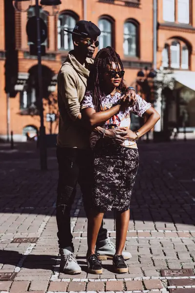 Genç, güzel siyah çift şehirde güneş gözlükleriyle poz veriyor.